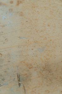 Image of sawdust on the floor, indicating a carpenter ant infestation, in need of professional carpenter ant removal services.
