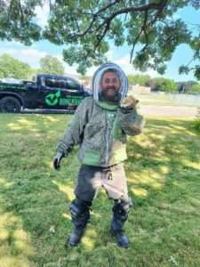 Image showcasing our tech Bryan removing a ground hornet nest, showing his care and attention to detail, keeping your yard happy and sting-free!